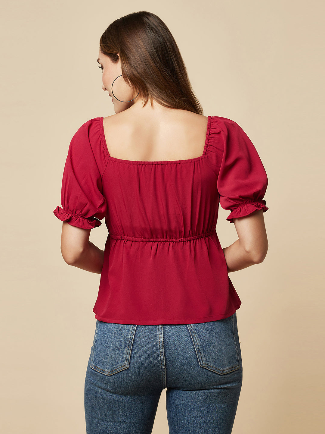 A Burgundy Solid Ruched Waist Peplum Top for Women is a stylish and flattering garment that is perfect for various occasions. The top features a beautiful shade of burgundy, which is perfect for adding a pop of color to any outfit. The ruched waistline creates a slimming effect, accentuating the natural curves of the body. The peplum detail adds a feminine and stylish touch to the design, making it perfect for a night out or a formal event.