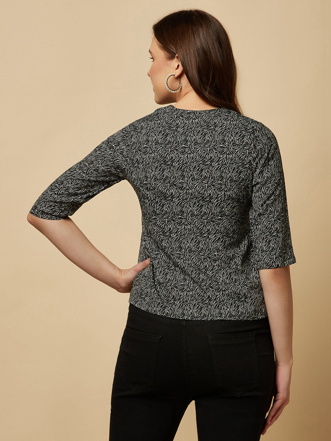 A black printed top with a front placket and ruched bust line is a stylish and elegant piece of clothing. The top has a simple and classic design with a front placket that adds a touch of sophistication to the outfit. The ruched bust line creates a flattering and feminine look, enhancing the wearer's curves.
