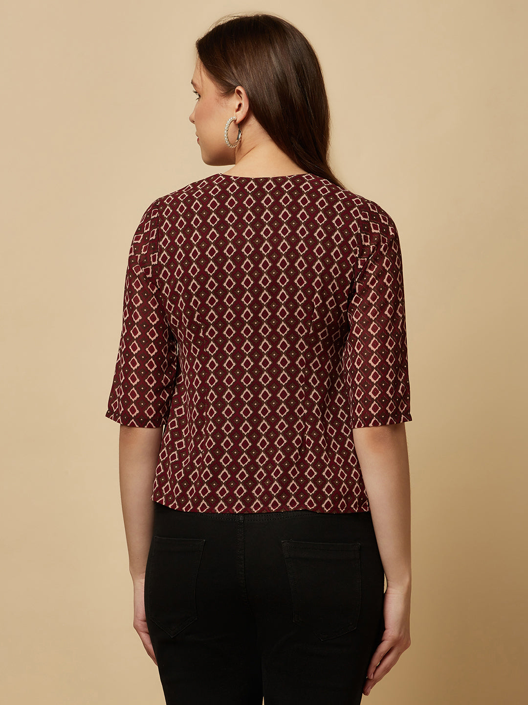 A brown printed top with a front placket and ruched bust line is a stylish and elegant piece of clothing. The top has a simple and classic design with a front placket that adds a touch of sophistication to the outfit. The ruched bust line creates a flattering and feminine look, enhancing the wearer's curves.