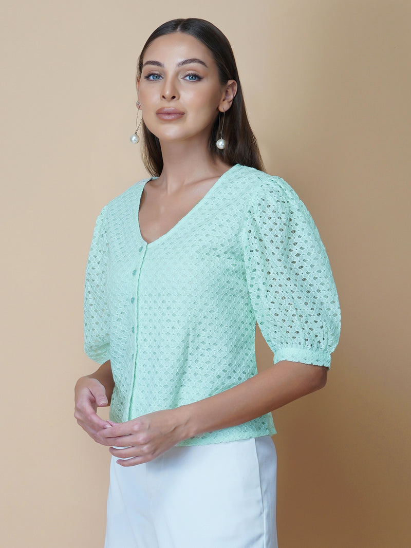 The Green Color Jacquard Mesh Women Top is a versatile and stylish piece of clothing that is perfect for both formal and casual occasions. The top features a classic V-neck design that is flattering for all body types, and it is adorned with a row of front buttons that add a touch of elegance and sophistication to the overall look.  Made from good-quality jacquard mesh fabric, this top is lightweight, breathable, and comfortable to wear all day long. 