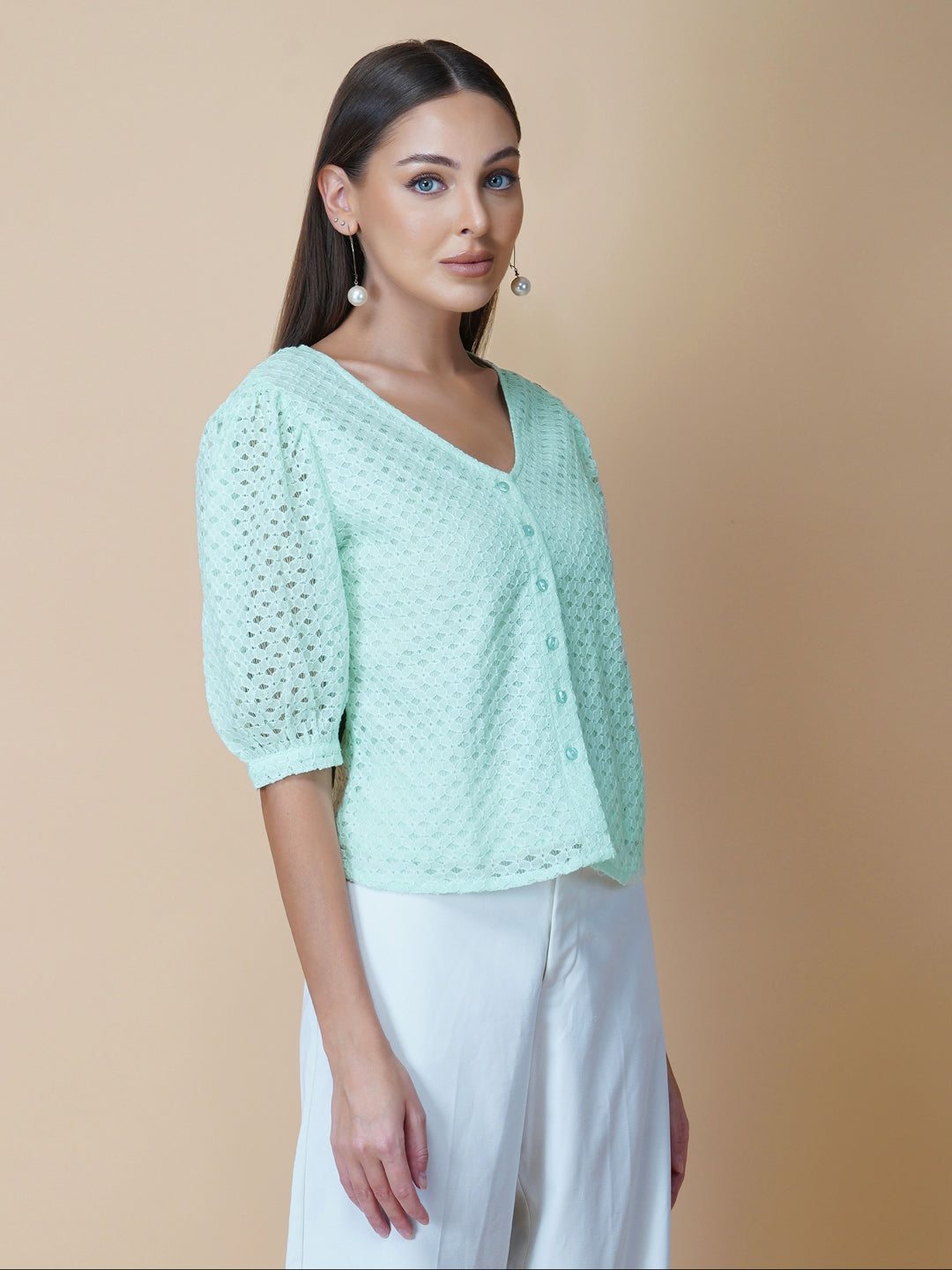 The Green Color Jacquard Mesh Women Top is a versatile and stylish piece of clothing that is perfect for both formal and casual occasions. The top features a classic V-neck design that is flattering for all body types, and it is adorned with a row of front buttons that add a touch of elegance and sophistication to the overall look.  Made from good-quality jacquard mesh fabric, this top is lightweight, breathable, and comfortable to wear all day long. 
