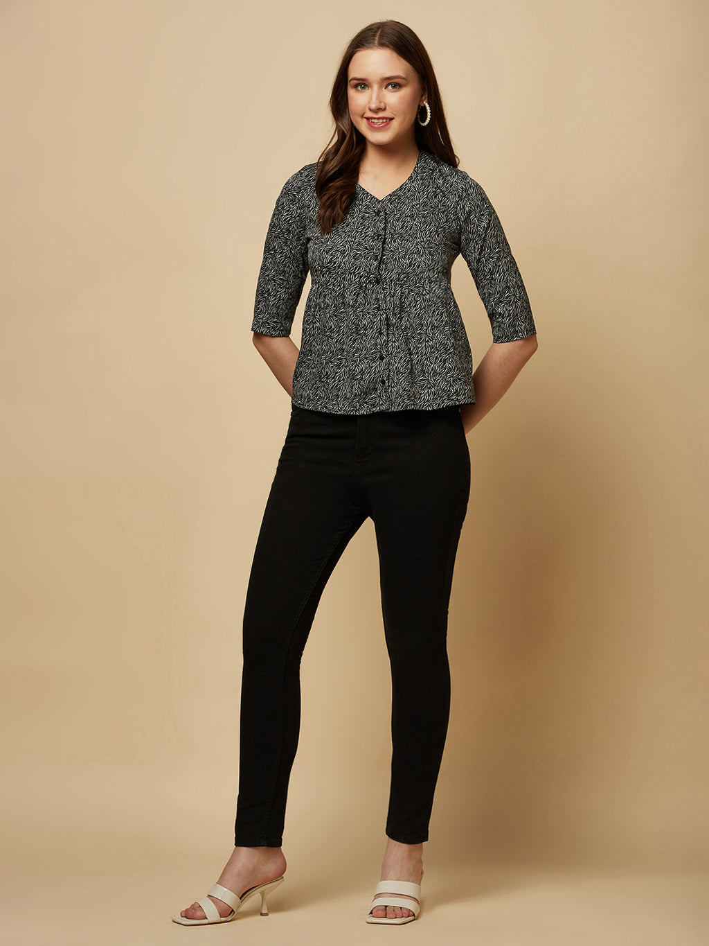 A black printed top with a front placket and ruched bust line is a stylish and elegant piece of clothing. The top has a simple and classic design with a front placket that adds a touch of sophistication to the outfit. The ruched bust line creates a flattering and feminine look, enhancing the wearer's curves.