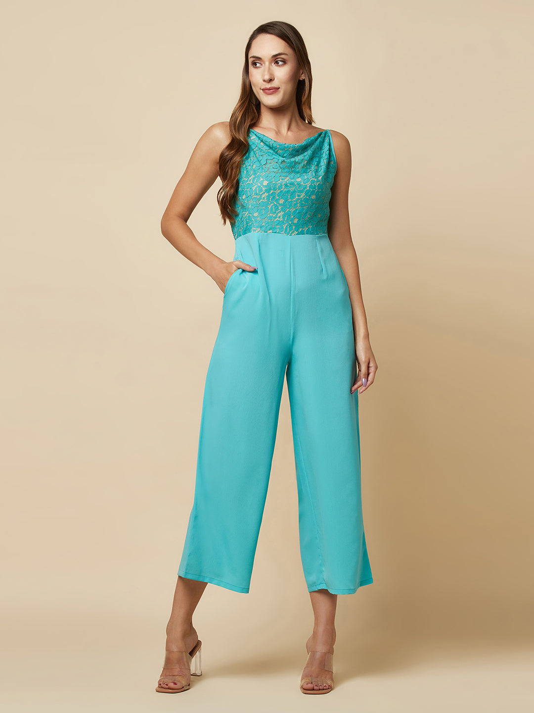 Blue cowl neck women jumpsuit with jacquard mesh body and crepe pants is a fashionable piece of clothing that is both elegant and comfortable. The cowl neck provides a flattering neckline that is both feminine and sophisticated.
