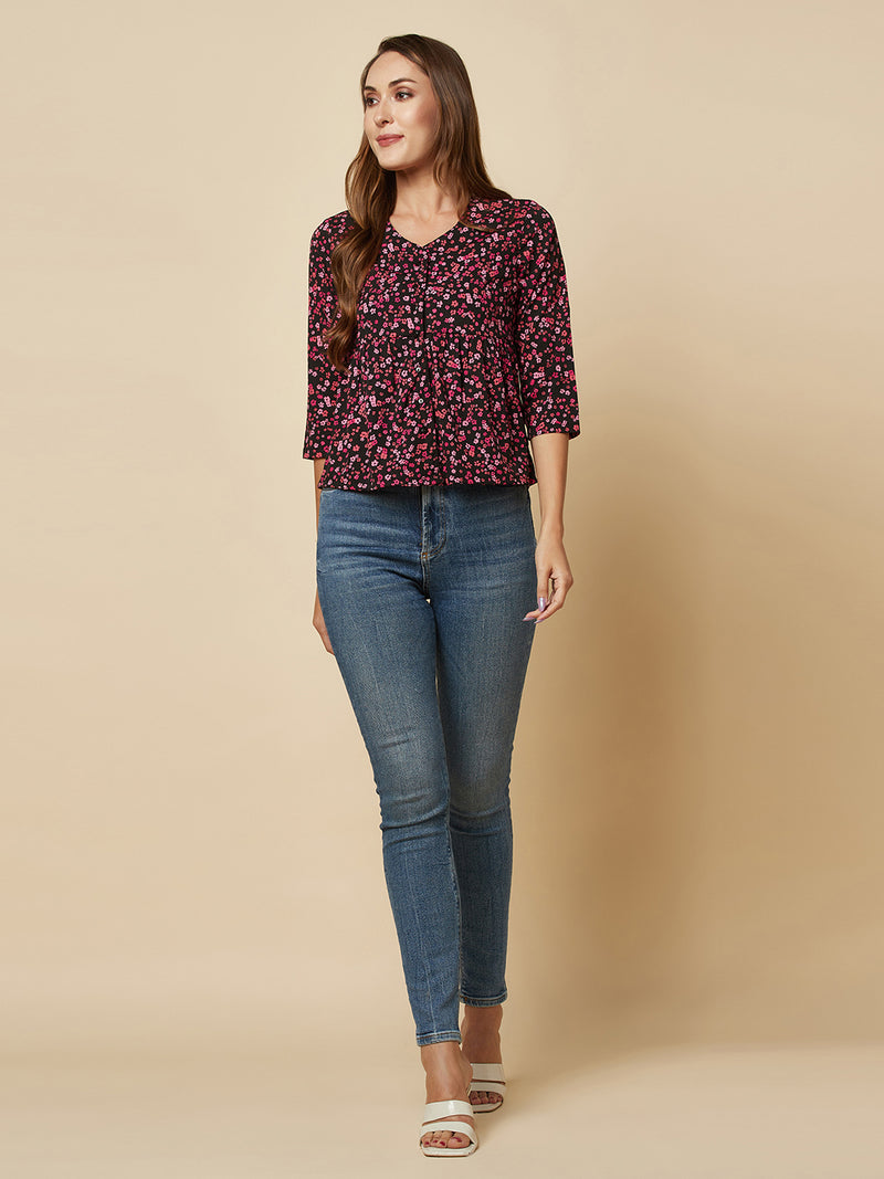 A pink floral printed top with a front placket and ruched bust line is a stylish and elegant piece of clothing. The top has a simple and classic design with a front placket that adds a touch of sophistication to the outfit. The ruched bust line creates a flattering and feminine look, enhancing the wearer's curves. 