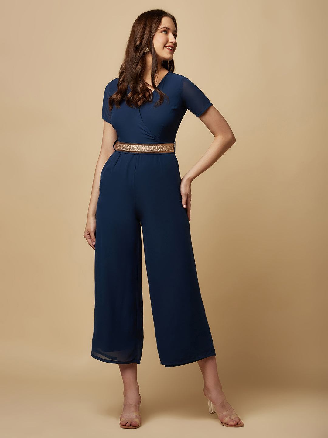 An Angrakkha style jumpsuit has a wrap-like design with a V-neckline and a side tie or belt closure. The jumpsuit may have a fitted bodice with wide-leg pants design.  The jumpsuit  is made from  polyester fabric with attached lining.  Golden Belt  clinches waist and gives it a more feminine look. Overall, a yellow color solid Angrakkha style women's jumpsuit with a belt is a stylish and comfortable outfit option for a variety of occasions.