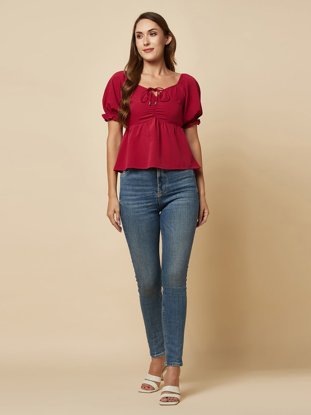 A Burgundy Solid Ruched Waist Peplum Top for Women is a stylish and flattering garment that is perfect for various occasions. The top features a beautiful shade of burgundy, which is perfect for adding a pop of color to any outfit. The ruched waistline creates a slimming effect, accentuating the natural curves of the body. The peplum detail adds a feminine and stylish touch to the design, making it perfect for a night out or a formal event.