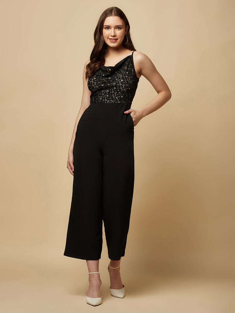 Black cowl neck women jumpsuit with jacquard mesh body and crepe pants is a fashionable piece of clothing that is both elegant and comfortable. The cowl neck provides a flattering neckline that is both feminine and sophisticated.  The jacquard mesh body adds a touch of glamour and texture to the piece, while the crepe pants provide a smooth and comfortable fit.