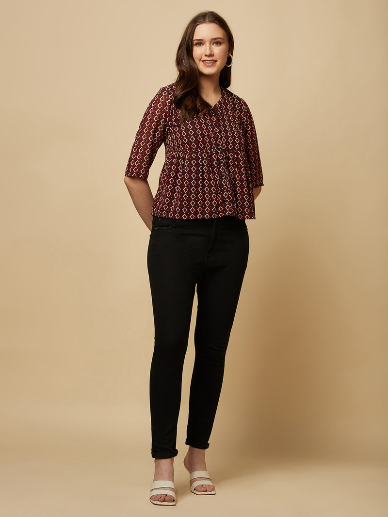 A brown printed top with a front placket and ruched bust line is a stylish and elegant piece of clothing. The top has a simple and classic design with a front placket that adds a touch of sophistication to the outfit. The ruched bust line creates a flattering and feminine look, enhancing the wearer's curves.
