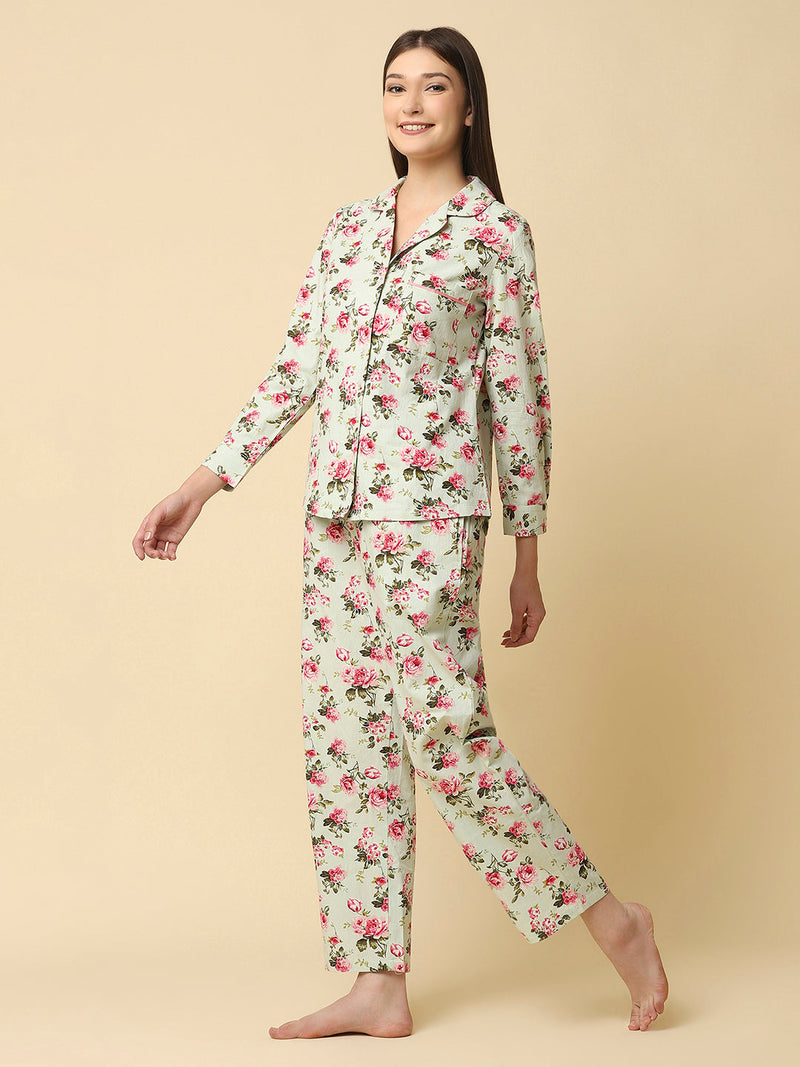 Green floral printed cotton night suit for women is a comfortable and stylish sleepwear option that features a soft, breathable cotton fabric and a beautiful floral print design. Typically, a cotton night suit for women consists of a matching set of a button up Shirt and bottom, usually in a relaxed fit style for maximum comfort.  The cotton fabric used in the night suit is highly absorbent, which means it can effectively absorb sweat and keep you feeling fresh and cool throughout the night. 