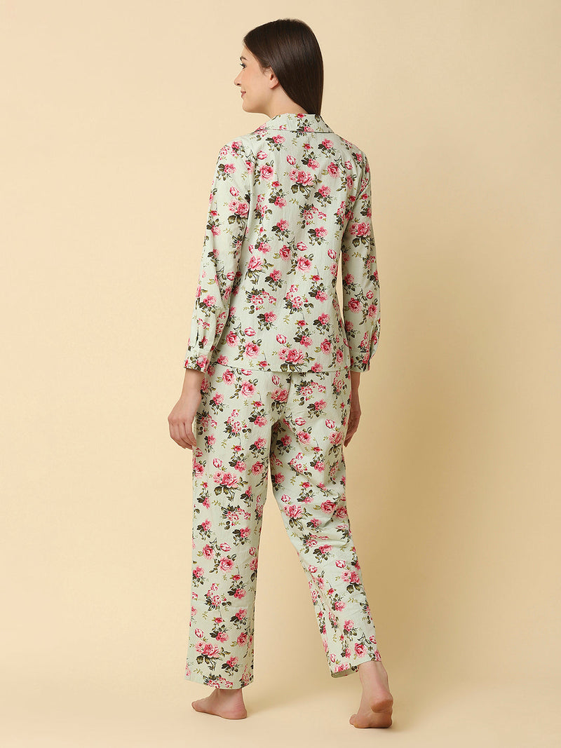 Green floral printed cotton night suit for women is a comfortable and stylish sleepwear option that features a soft, breathable cotton fabric and a beautiful floral print design. Typically, a cotton night suit for women consists of a matching set of a button up Shirt and bottom, usually in a relaxed fit style for maximum comfort.  The cotton fabric used in the night suit is highly absorbent, which means it can effectively absorb sweat and keep you feeling fresh and cool throughout the night. 