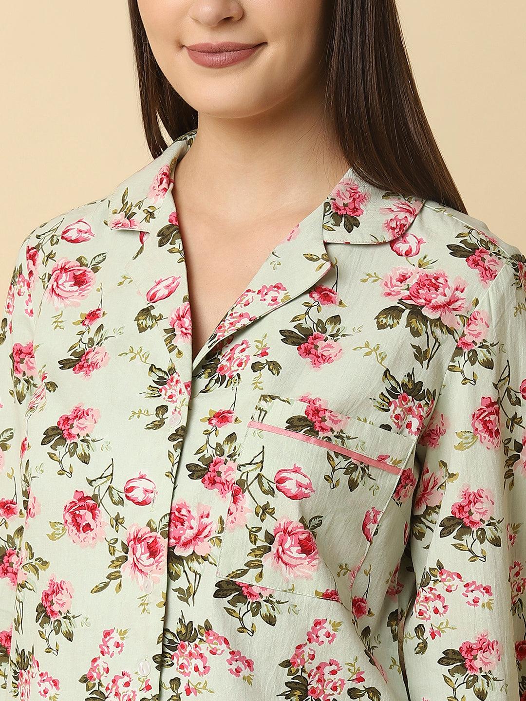 Green floral printed cotton night suit for women is a comfortable and stylish sleepwear option that features a soft, breathable cotton fabric and a beautiful floral print design. Typically, a cotton night suit for women consists of a matching set of a button up Shirt and bottom, usually in a relaxed fit style for maximum comfort.  The cotton fabric used in the night suit is highly absorbent, which means it can effectively absorb sweat and keep you feeling fresh and cool throughout the night. 