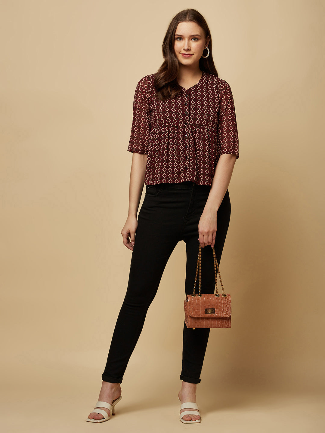 A brown printed top with a front placket and ruched bust line is a stylish and elegant piece of clothing. The top has a simple and classic design with a front placket that adds a touch of sophistication to the outfit. The ruched bust line creates a flattering and feminine look, enhancing the wearer's curves.