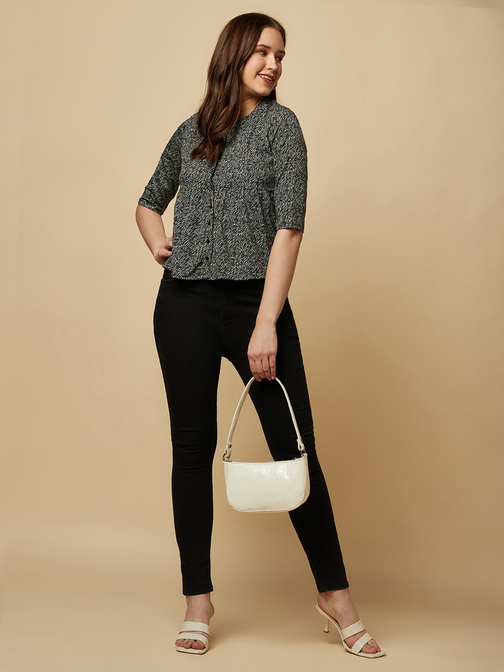 A black printed top with a front placket and ruched bust line is a stylish and elegant piece of clothing. The top has a simple and classic design with a front placket that adds a touch of sophistication to the outfit. The ruched bust line creates a flattering and feminine look, enhancing the wearer's curves.