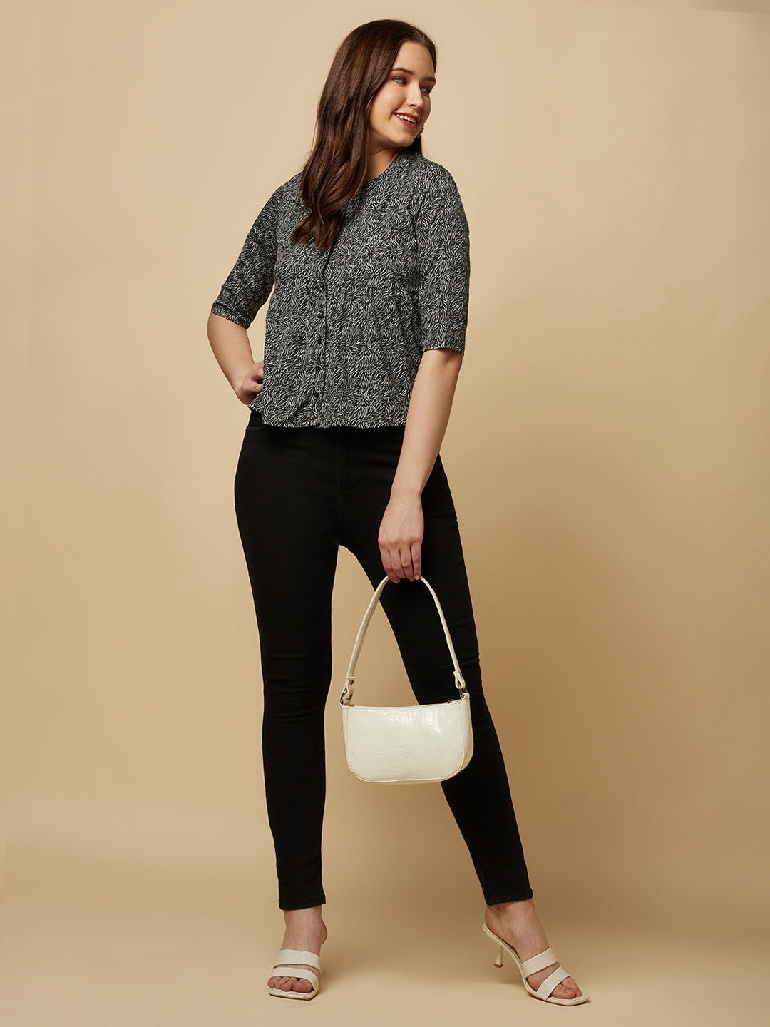 A black printed top with a front placket and ruched bust line is a stylish and elegant piece of clothing. The top has a simple and classic design with a front placket that adds a touch of sophistication to the outfit. The ruched bust line creates a flattering and feminine look, enhancing the wearer's curves.
