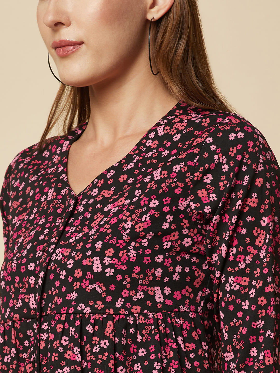 A pink floral printed top with a front placket and ruched bust line is a stylish and elegant piece of clothing. The top has a simple and classic design with a front placket that adds a touch of sophistication to the outfit. The ruched bust line creates a flattering and feminine look, enhancing the wearer's curves. 