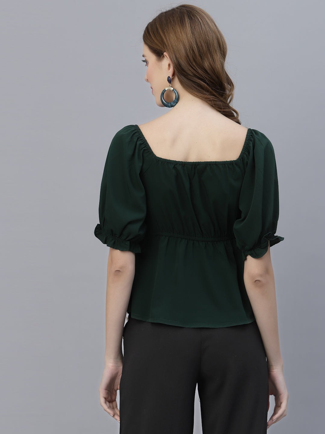 A Green Solid Ruched Waist Peplum Top for Women is a stylish and flattering garment that is perfect for various occasions. The top features a beautiful shade of green, which is perfect for adding a pop of color to any outfit. The ruched waistline creates a slimming effect, accentuating the natural curves of the body. The peplum detail adds a feminine and stylish touch to the design, making it perfect for a night out or a formal event.