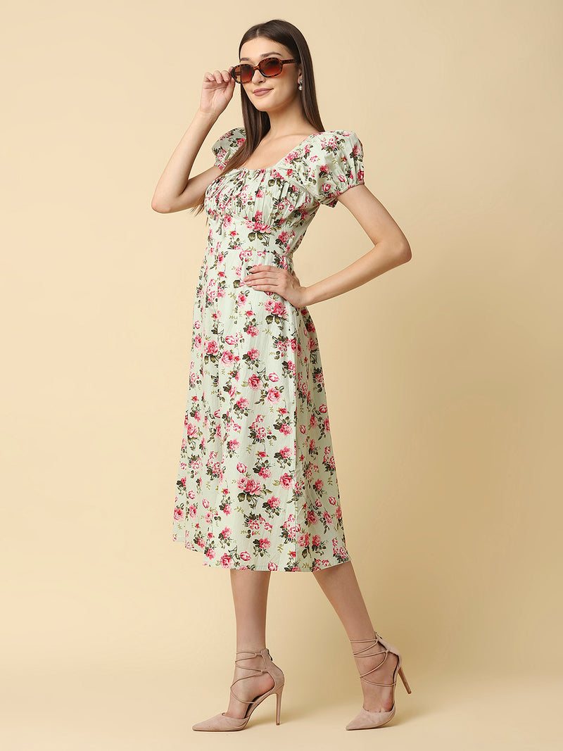 This green floral Printed Women Dress In Cotton is a charming and elegant piece that is sure to catch the eye. Made from soft and breathable cotton fabric, it is perfect for warm weather and will keep you comfortable all day long. The dress features a beautiful floral print in shades of pink, white, and green that adds a pop of color to your wardrobe.  The ruched bust and empire waist create a flattering silhouette that accentuates your curves and adds a feminine touch to the dress. 