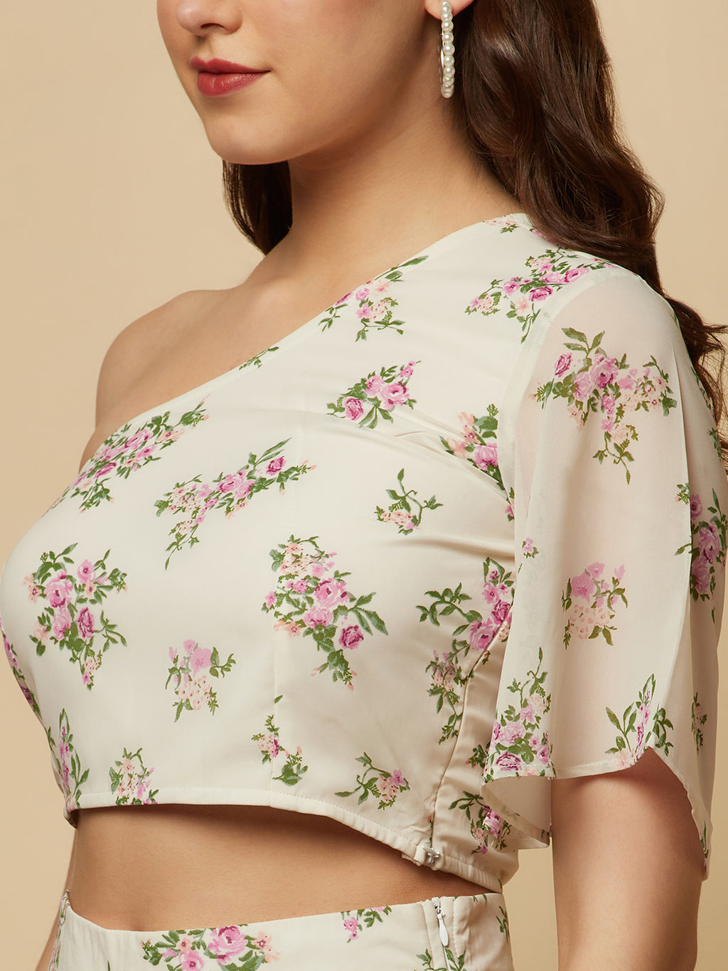 The White Floral Printed Palazzo With One Shoulder Crop Top Co-ords is a stylish and elegant outfit designed for women. This set features a white palazzo pant and a one-shoulder crop top, both adorned with a beautiful floral print in shades of pink, white, and green. The palazzo pants are made of a lightweight and breathable fabric that flows elegantly as you move, providing both comfort and style. 