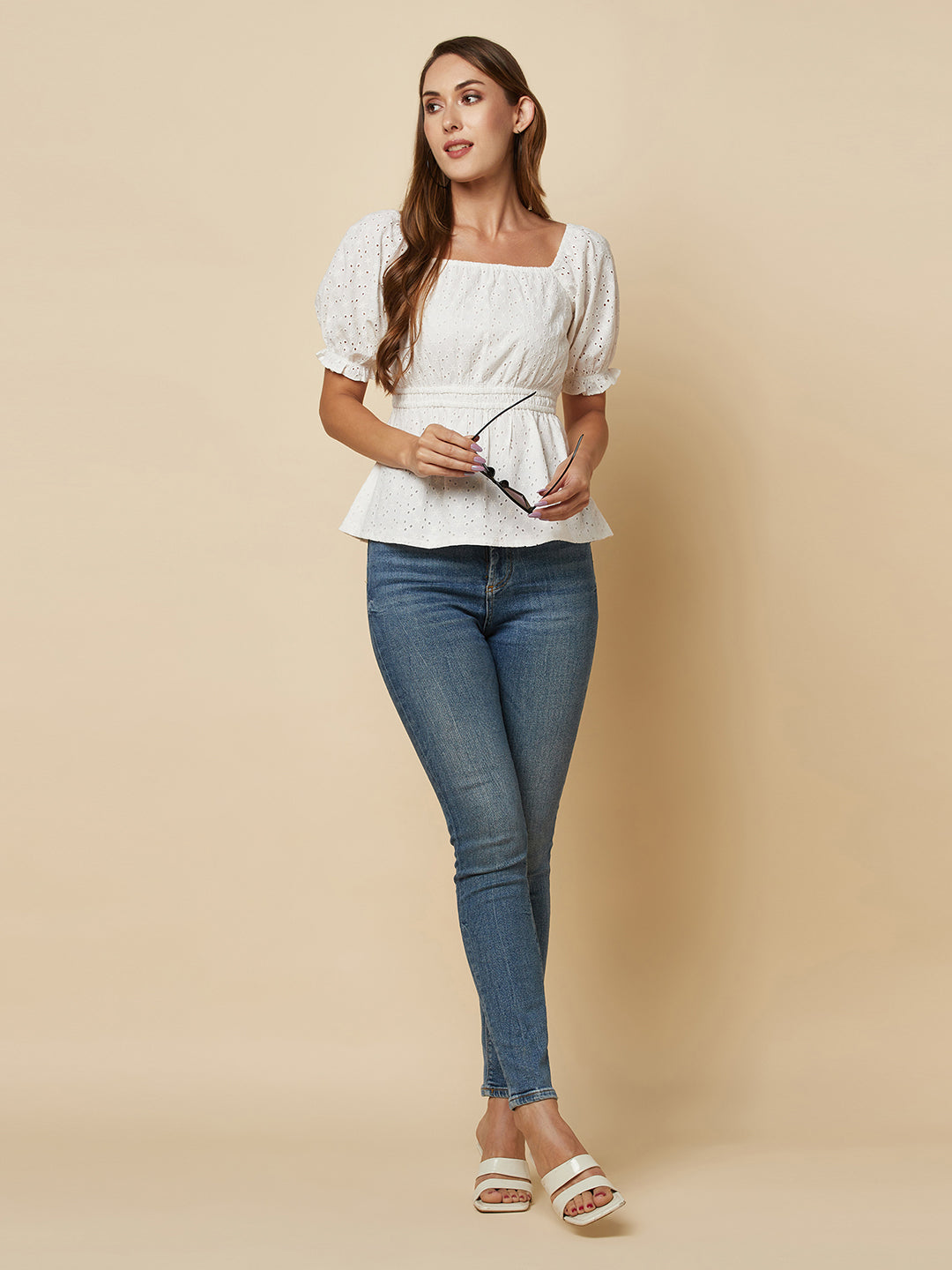 The White Cotton Schiffli Women Top With Ruched Waist And Lining is a stylish and elegant piece of clothing designed for women who appreciate comfort and fashion. This top is made of high-quality cotton material that is soft, breathable, and lightweight, making it perfect for wearing in warm weather.  The top is designed with a beautiful Schiffli embroidery pattern that gives it a unique and classy look. The ruched waist of the top accentuates the waistline, creating a flattering silhouette for the wearer. 