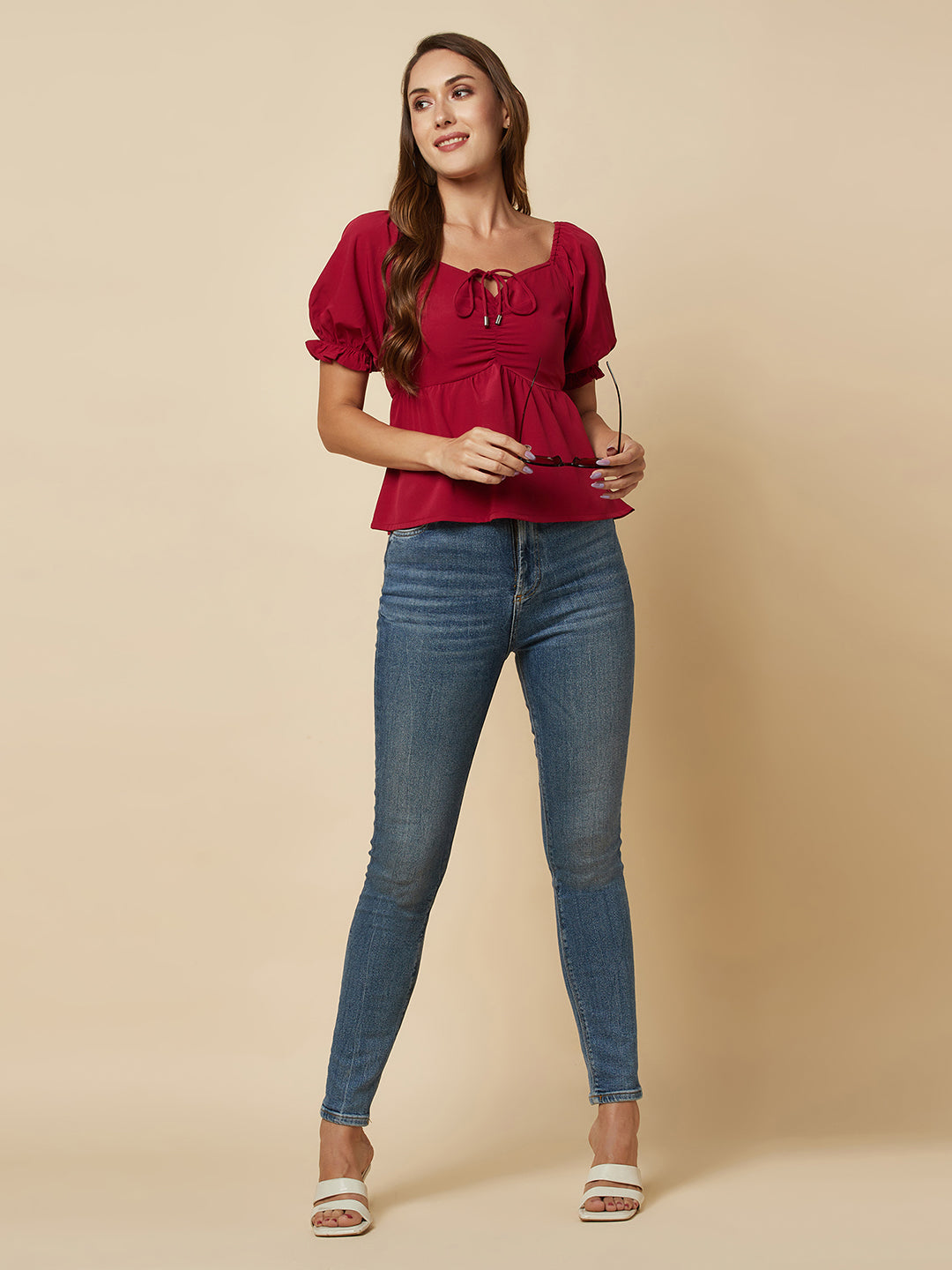A Burgundy Solid Ruched Waist Peplum Top for Women is a stylish and flattering garment that is perfect for various occasions. The top features a beautiful shade of burgundy, which is perfect for adding a pop of color to any outfit. The ruched waistline creates a slimming effect, accentuating the natural curves of the body. The peplum detail adds a feminine and stylish touch to the design, making it perfect for a night out or a formal event.