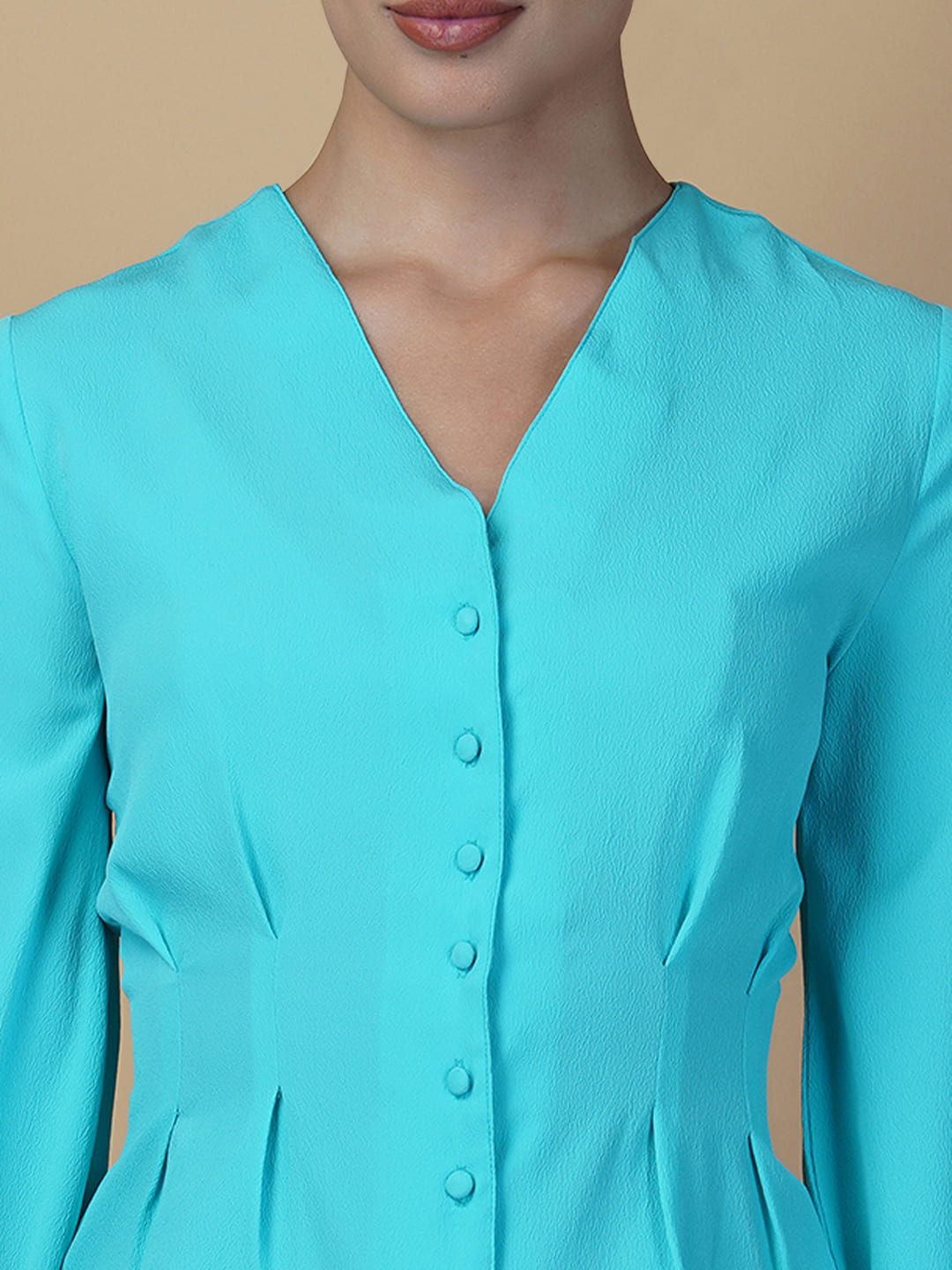 Turquoise color waist pleated women's top with full sleeves is a stylish and fashionable choice for women who want to add some color and texture to their wardrobe. Turquoise is a vibrant and eye-catching color that can help you stand out in a crowd, while the waist pleats add a unique and flattering touch to the design.